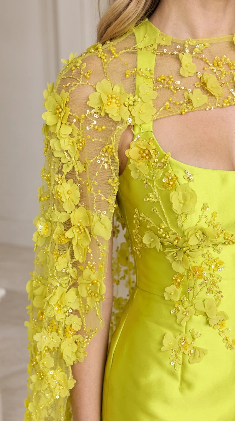 Close-up detail of sheer cape with intricate 3D floral appliqués and beads