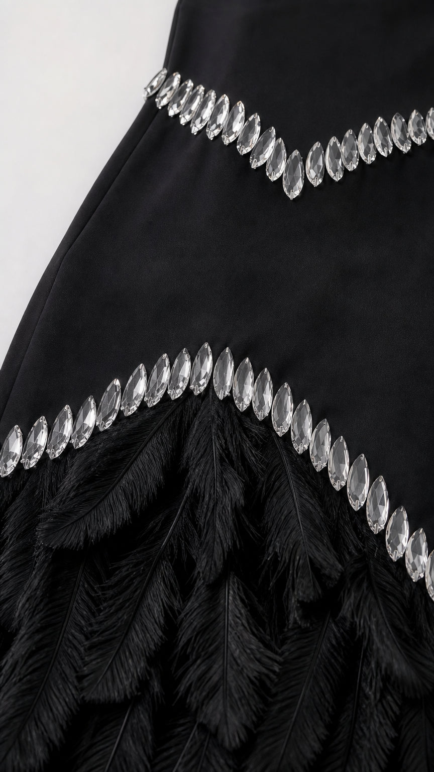 Close-up detail of crystal embellishments and feather fringe hem