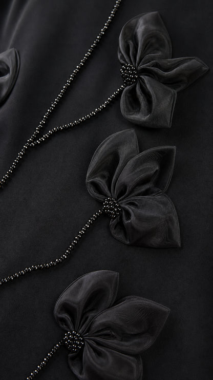 Close-up detail of 3D black flower petals and beaded vine embellishment