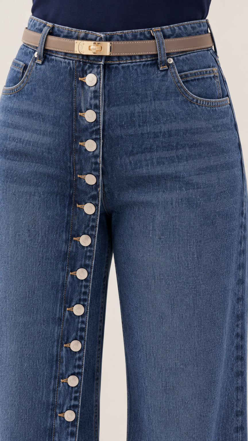 Close-up detail of high waist, belt loops, and vertical front button placket on denim