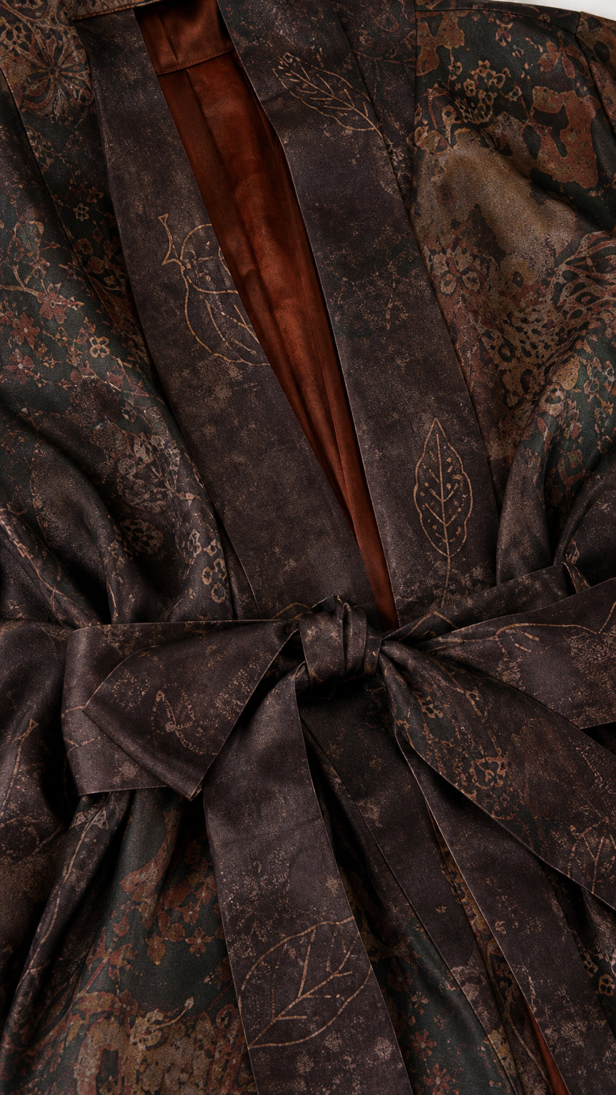 Close-up detail of smooth satin fabric and tie waist on dark brown kimono