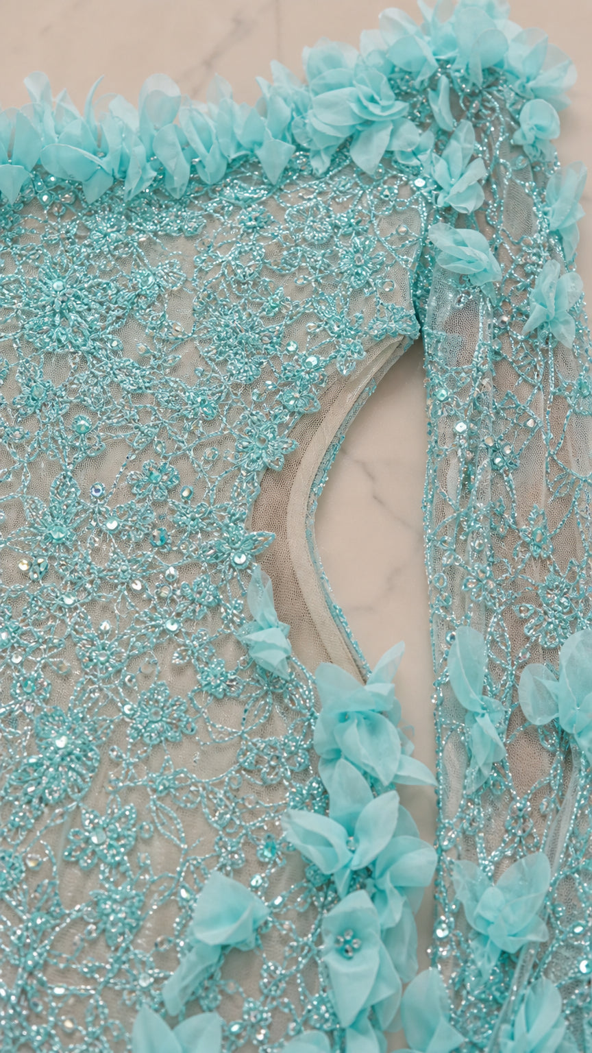 Close up fabric detail of light blue sequin and 3D flower mesh