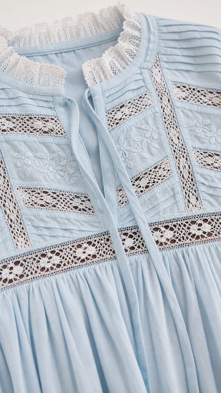 Close-up of Light Blue dress showing delicate lace insets, embroidery, and pin-tuck details