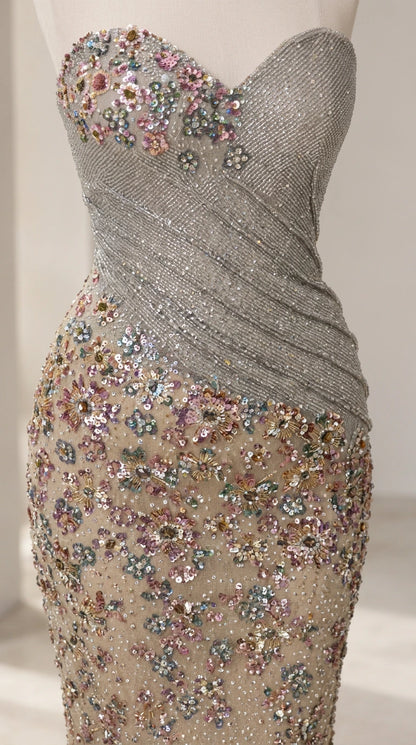 Close-up detail of floral beadwork and diagonal ruched bodice