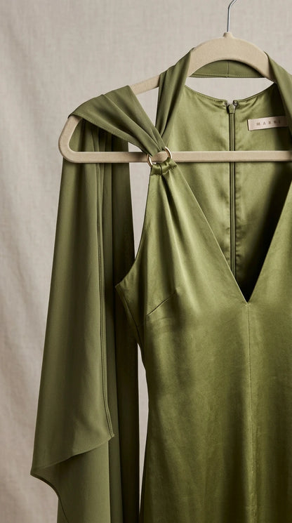 Close-up of halter neckline and metal ring shoulder detail on satin dress