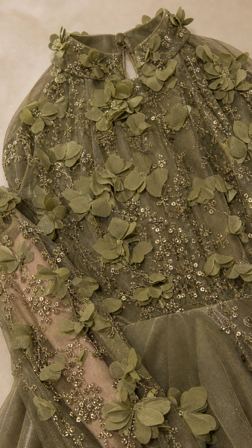 Close-up detail of 3D floral appliques, tonal sequins, and mesh fabric texture on halter neckline