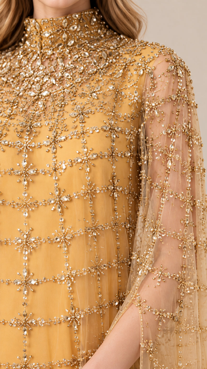 Close-up detail of embellished high neckline and beaded grid pattern on gold cape gown