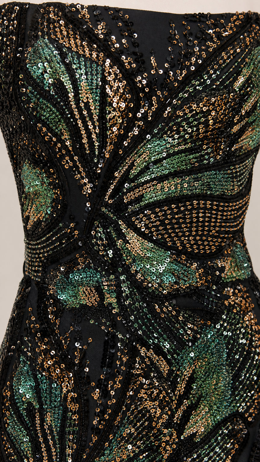 Close-up detail of shimmering green and gold sequin leaf pattern on black mesh fabric