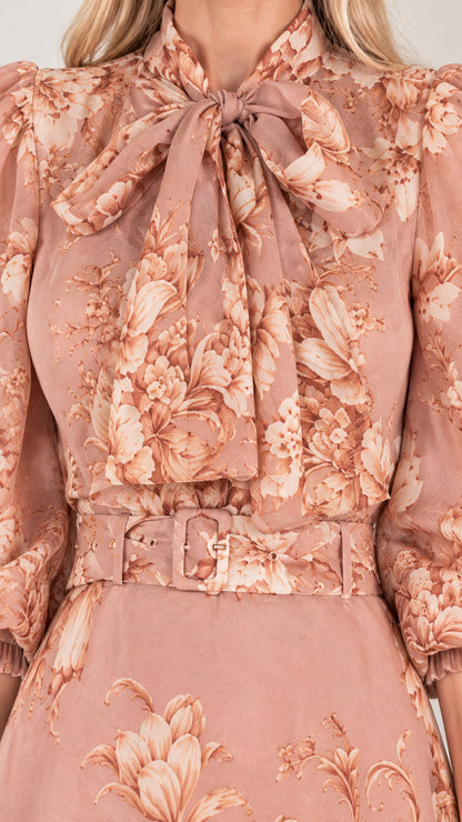 Close-up detail of bow tie neckline, floral pattern, and matching buckle belt on dusty rose dress