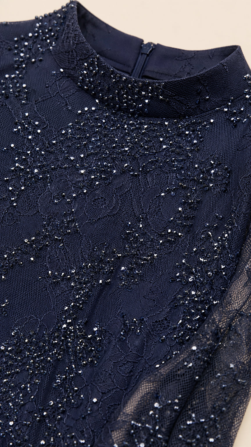 Close-up detail of navy blue sequined lace fabric and mock neckline with zipper