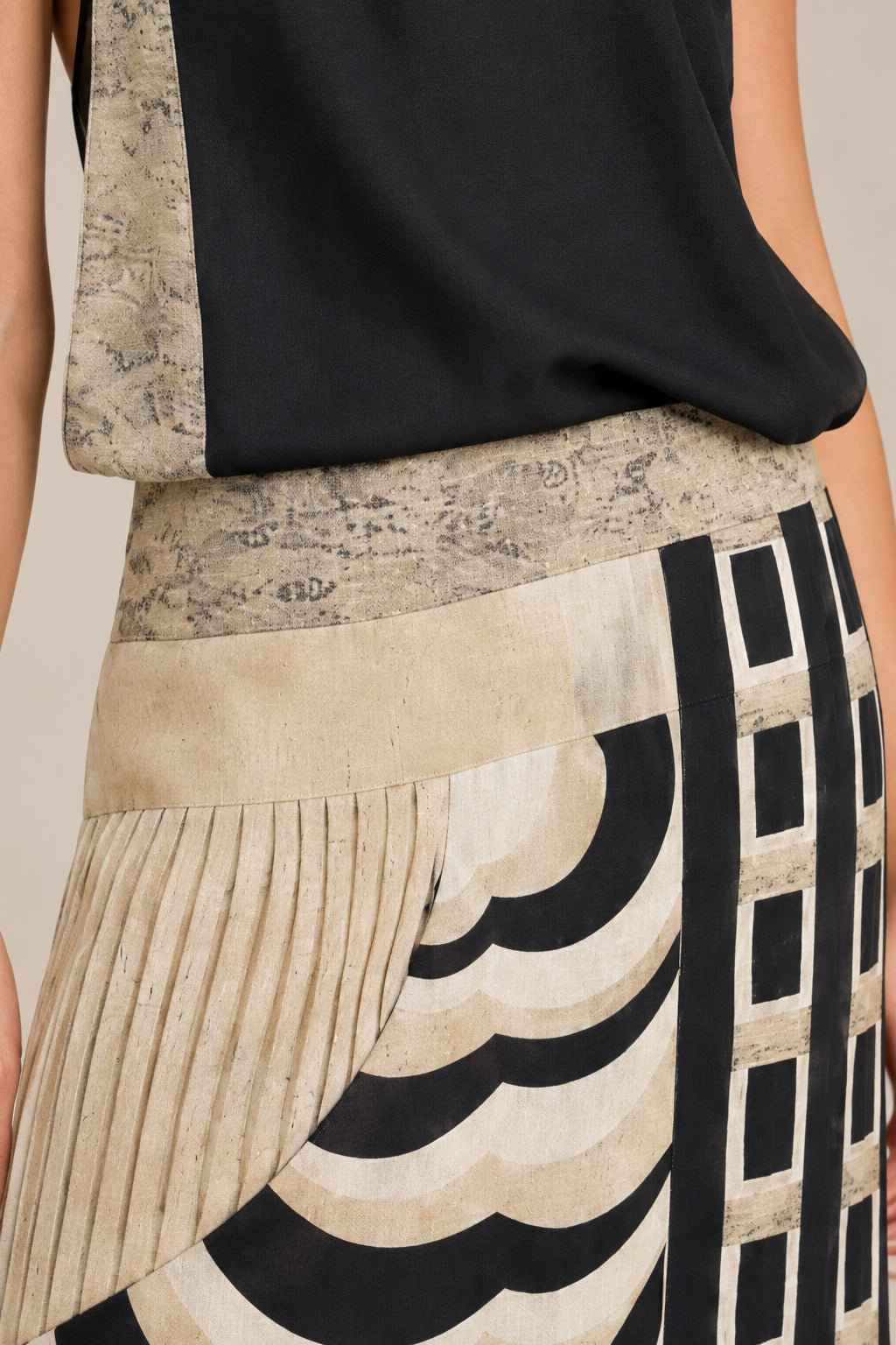 Close-up detail of textured pleating and graphic pattern on maxi dress