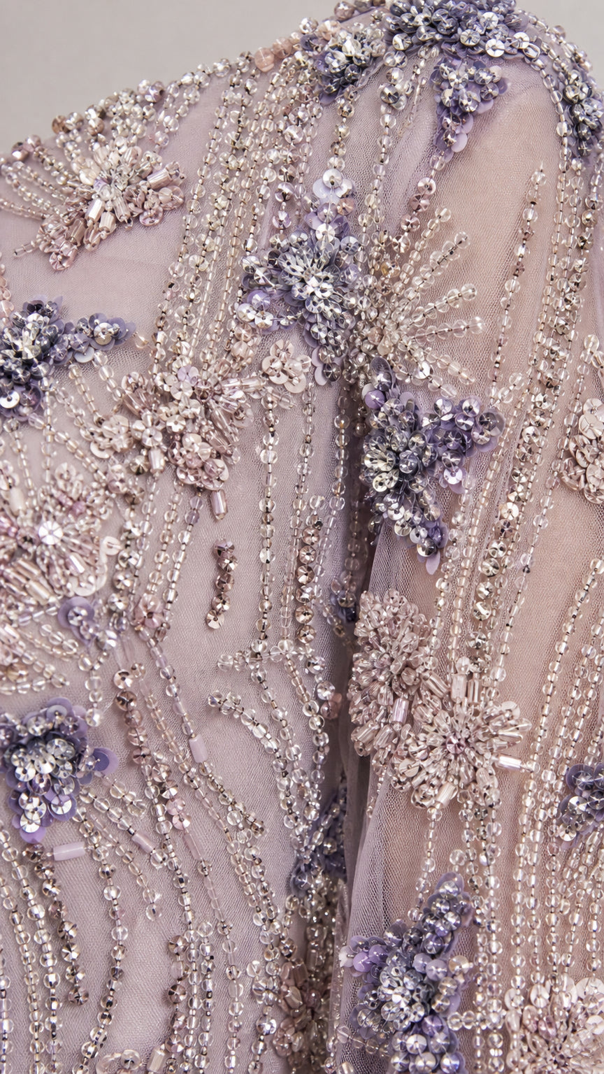 Close-up of intricate beadwork and floral embroidery on lavender gown