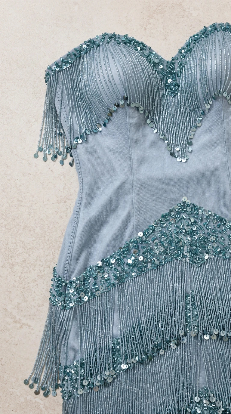 Close-up detail of dusty blue bodice with intricate beading and fringe trim