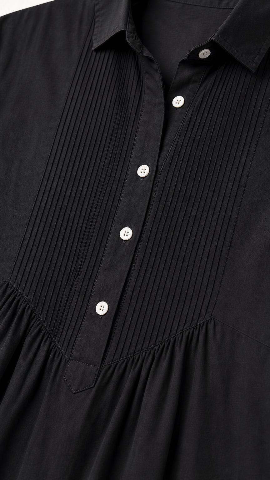 Close-up detail of front pintuck pleats and buttons on black shirt dress