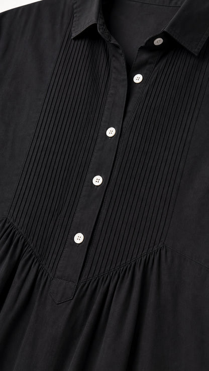 Close-up detail of front pintuck pleats and buttons on black shirt dress