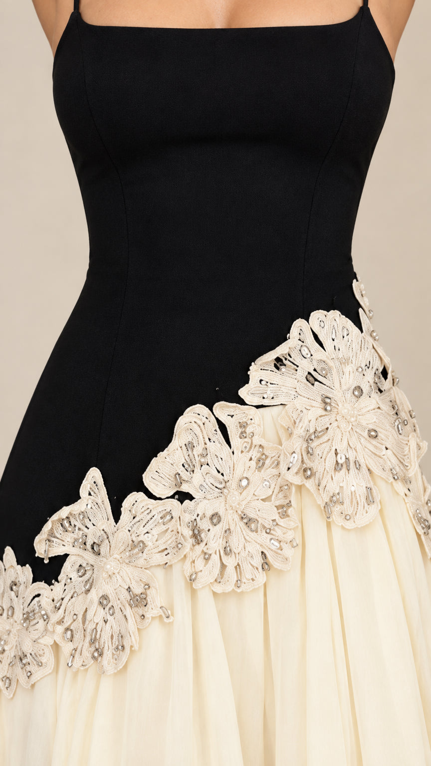 Close-up detail of embroidered floral lace appliqué along the dropped waistline