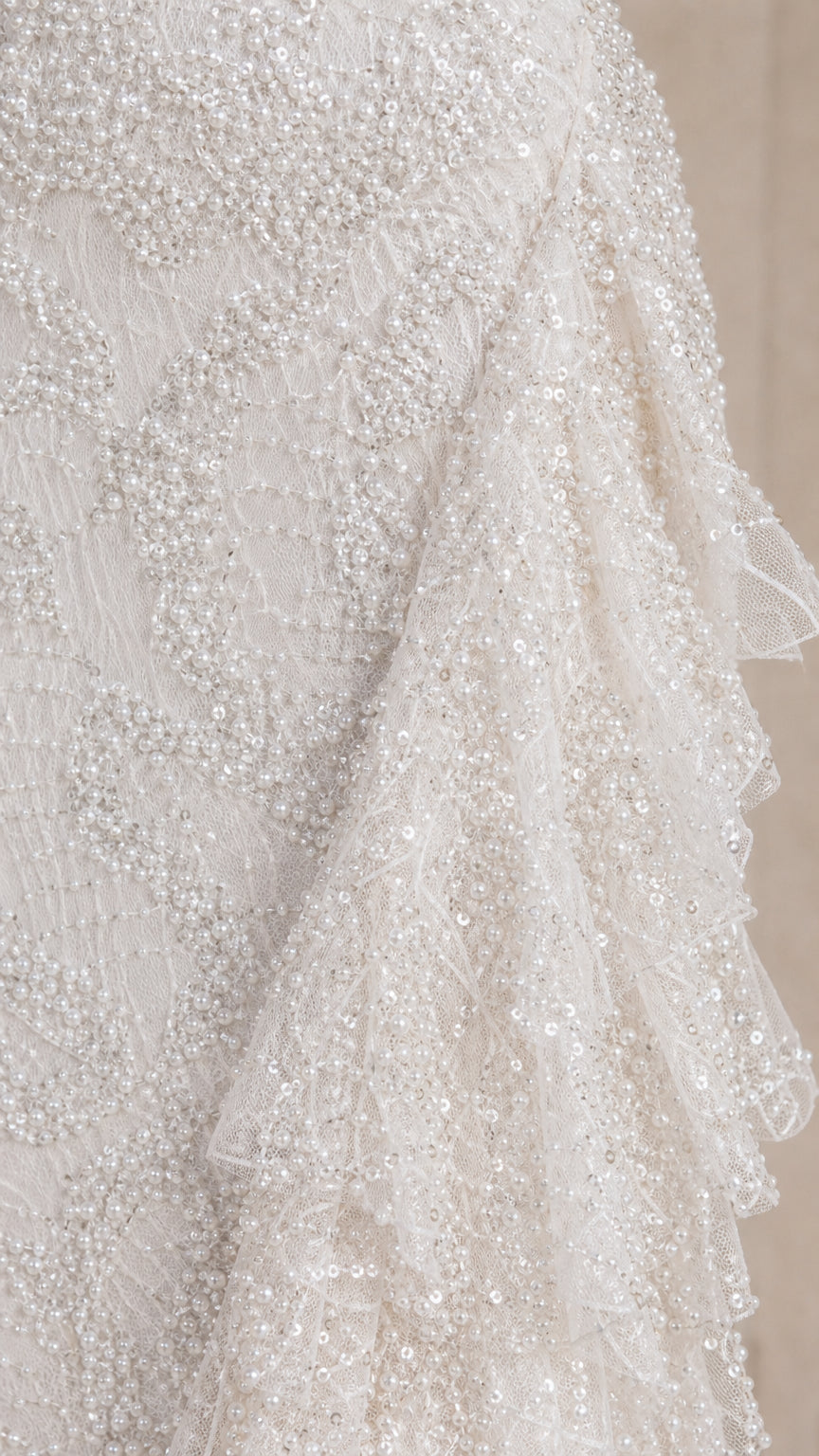 Close-up detail of textured sequin lace fabric and cascading tiered ruffles