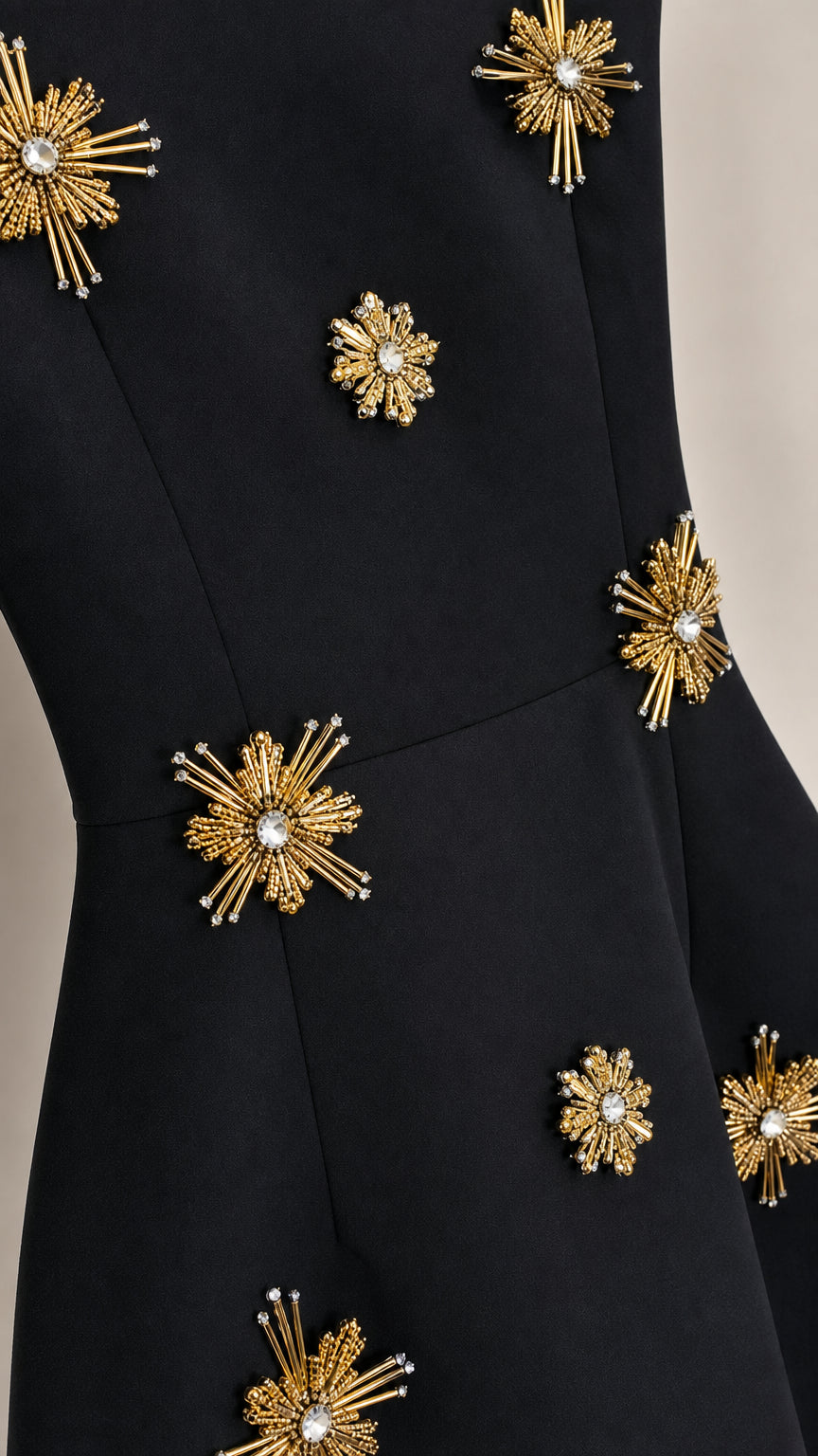 Close-up detail of rhinestone starburst embellishments on black dress