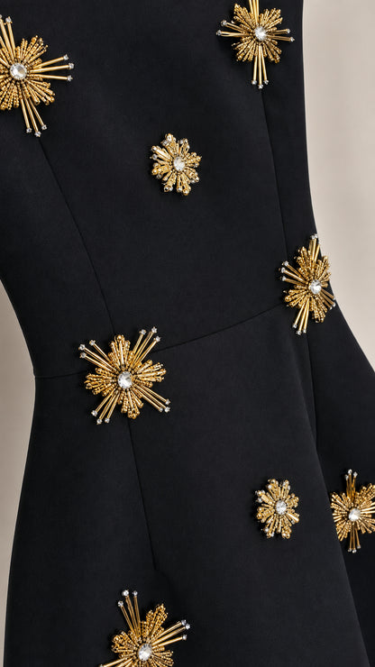 Close-up detail of rhinestone starburst embellishments on black dress