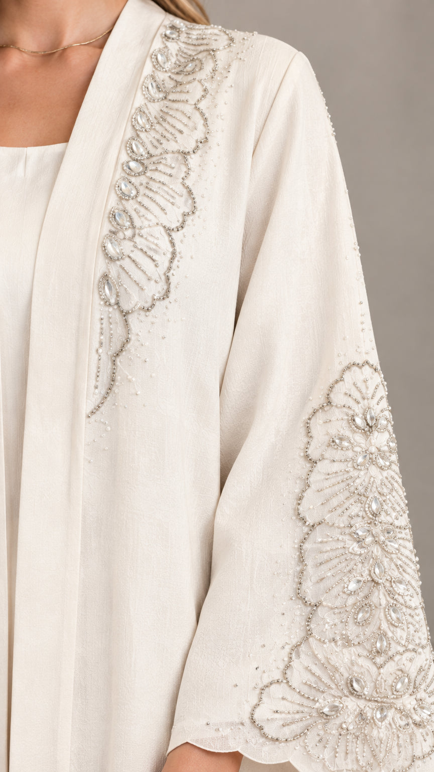 Close-up of intricate silver floral embroidery on neckline and sleeve cuff