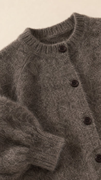 Close-up detail of charcoal grey fuzzy cardigan neckline, buttons, and texture