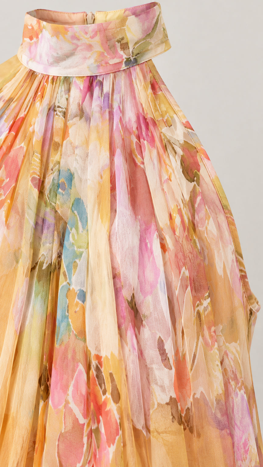 Close-up detail of high halter collar and pleated watercolor chiffon fabric