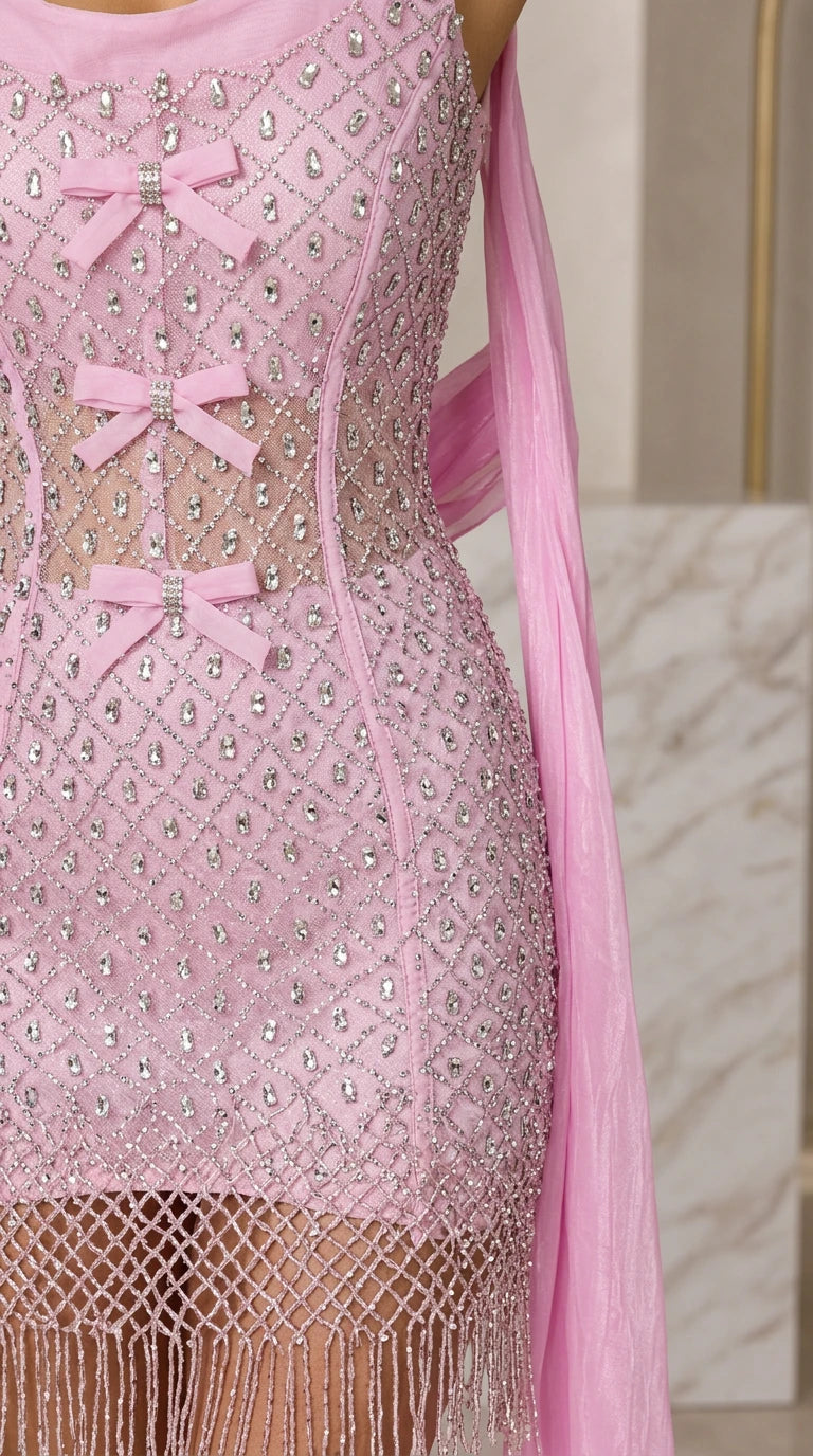 Close up of sheer corset bodice with bow details and rhinestone embellishments