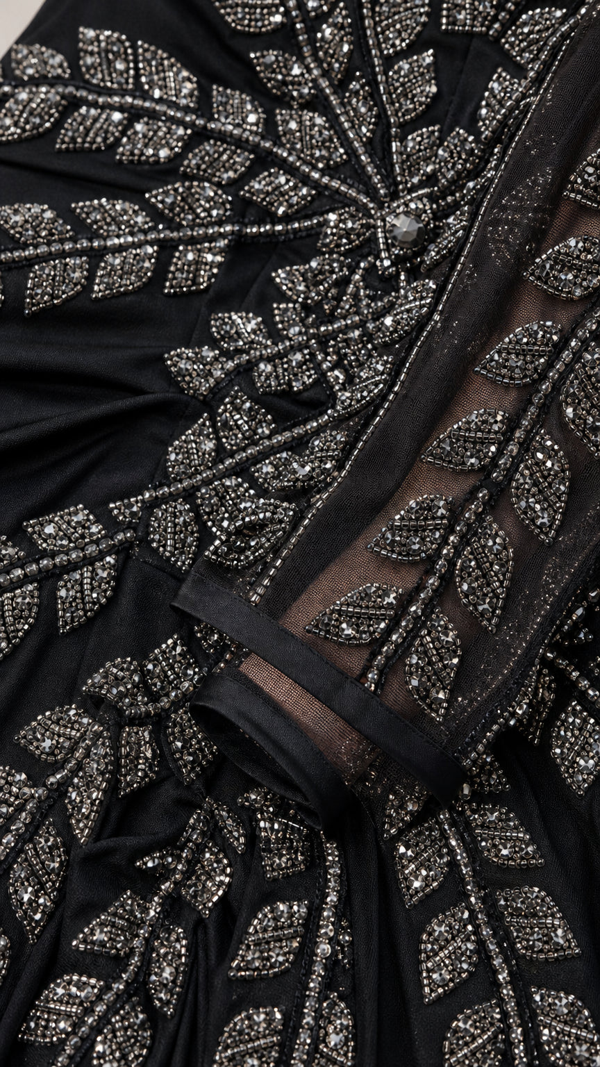 Close up of intricate metallic leaf beadwork on black evening gown