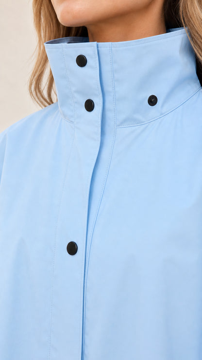 Close-up of high snap collar detail on light blue jacket