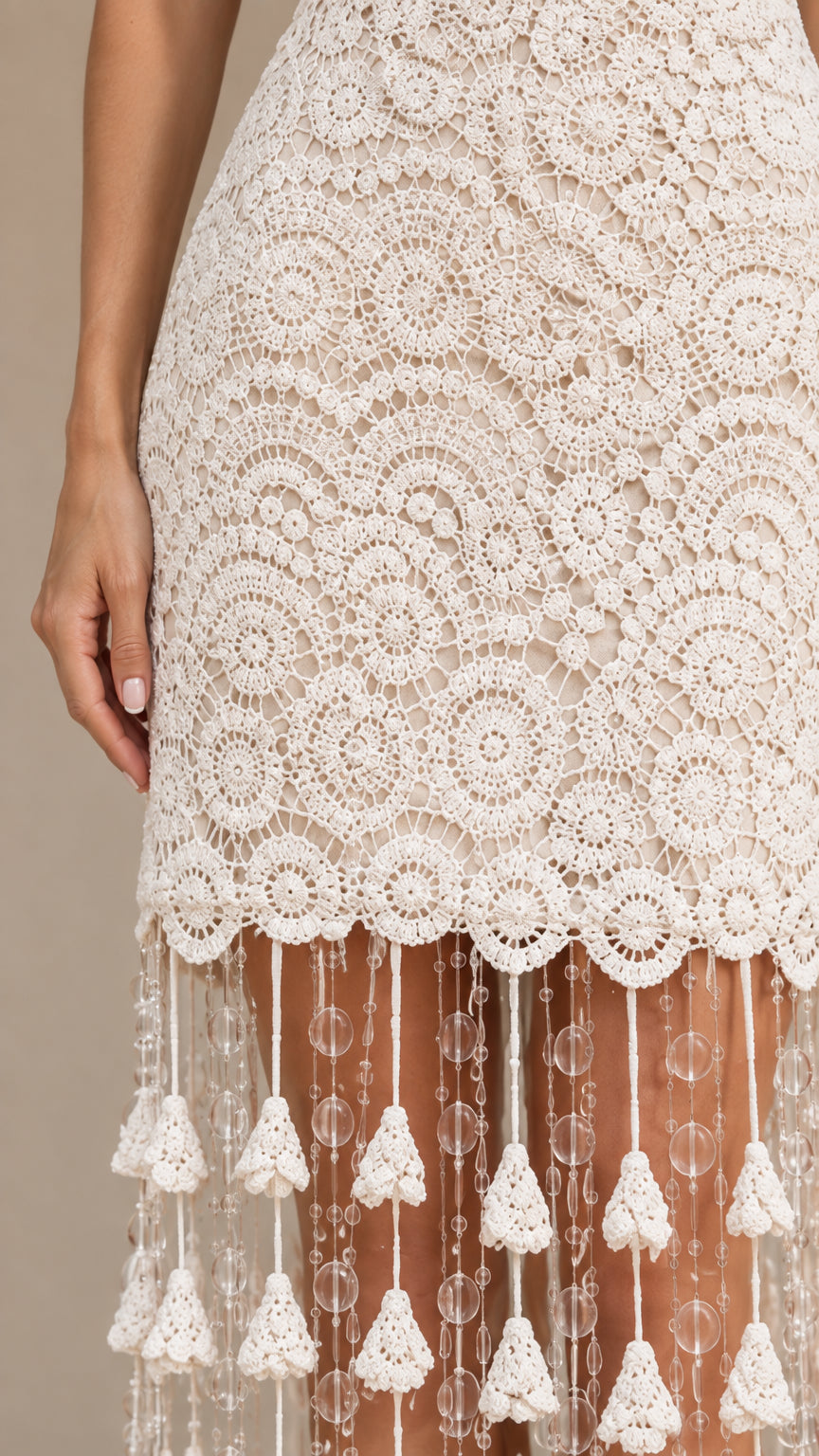 Close-up of intricate circular lace and tiered beaded tassel hem details