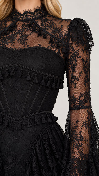 Close-up detail of black corset bodice with structured lines and tassel fringe trim