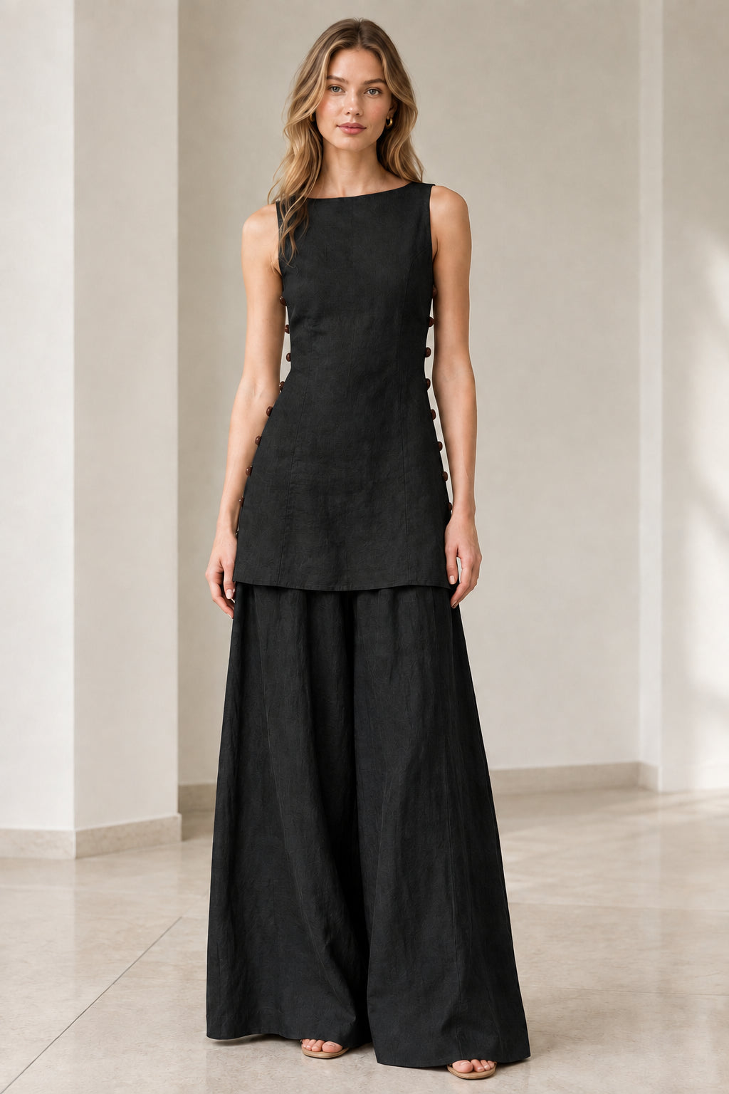 Model wearing solid black sleeveless tunic top and matching black wide-leg pants set