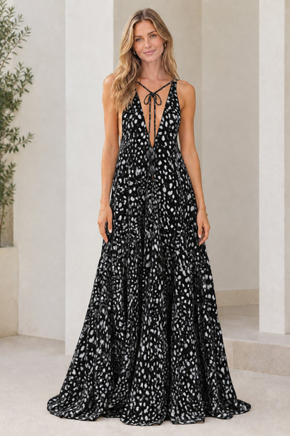 Model wearing black dotted print sleeveless plunge tiered maxi dress