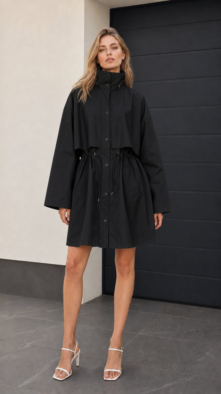 Front full-length view of woman wearing black drawstring trench parka jacket