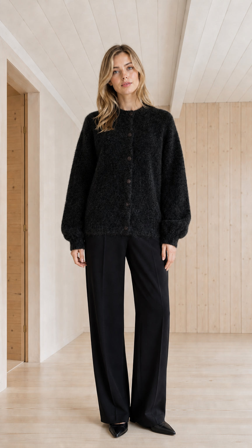 Model wearing black fuzzy crewneck button-front cardigan sweater