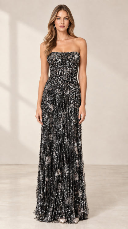 Front view of model wearing black strapless beaded fringe formal dress