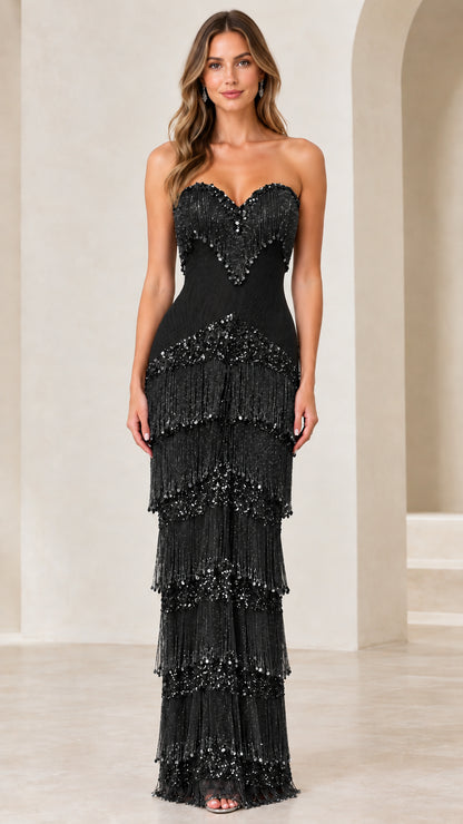 Front view of woman wearing black strapless sequined fringe evening gown