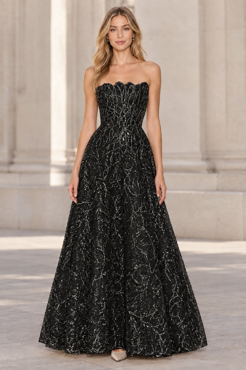 Front view of model wearing black strapless embellished A-line evening gown
