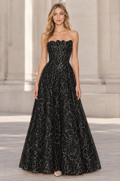 Front view of model wearing black strapless embellished A-line evening gown