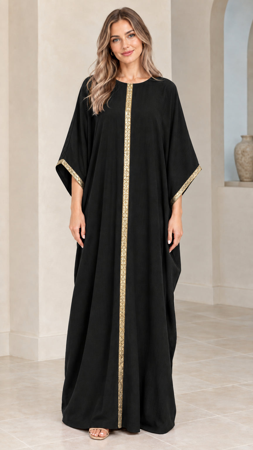 Full front view of model wearing black kaftan maxi dress with gold trim
