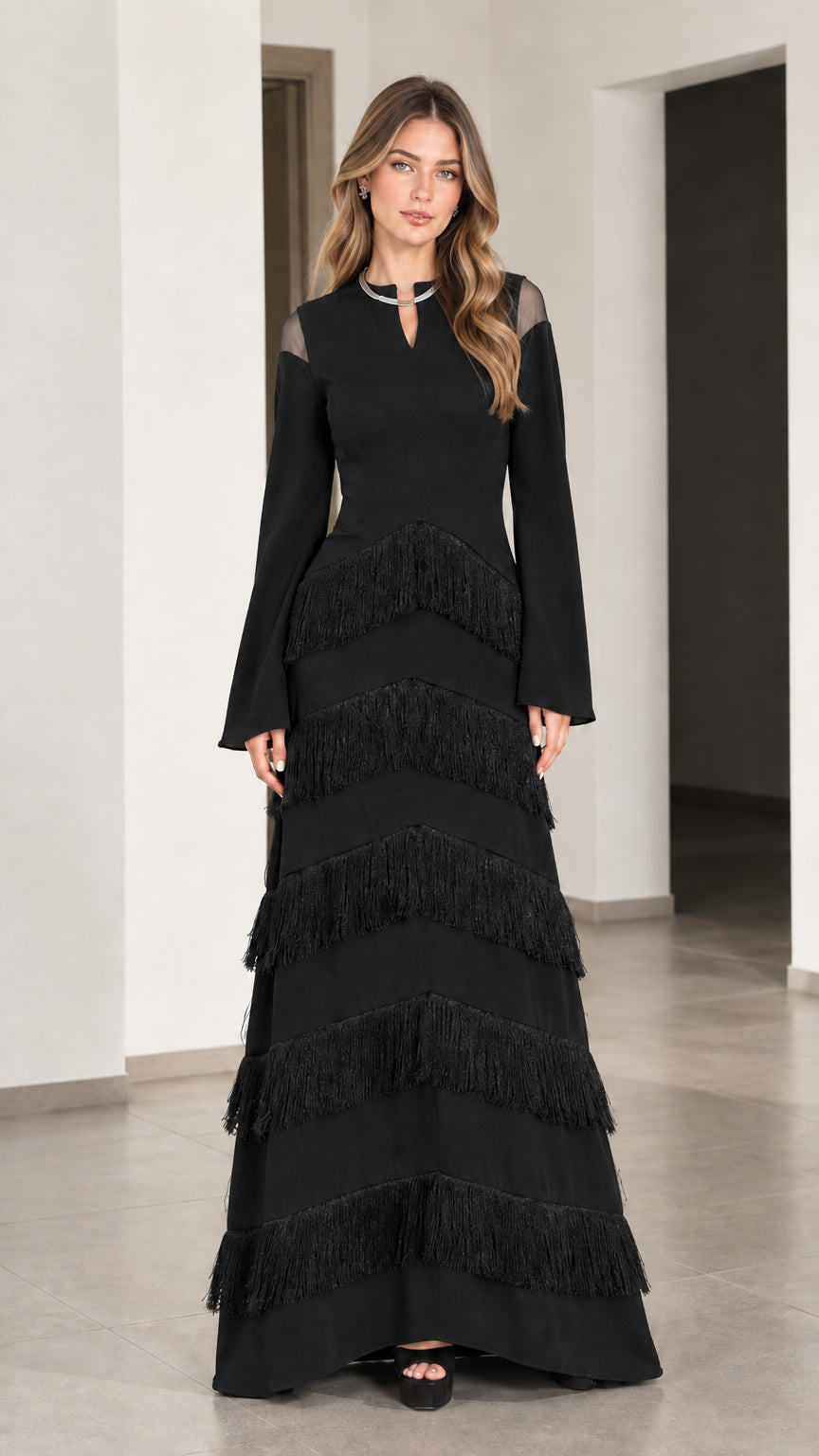 Front full view of Black long sleeve tiered fringe maxi evening gown