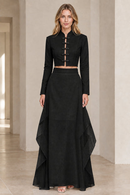 Front view of model wearing black frog button crop top and layered maxi skirt set