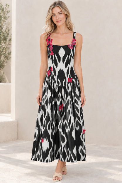 Model wearing black and white ikat print square neck maxi dress with butterfly accents