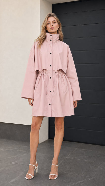 Front full-length view of woman wearing blush pink drawstring trench jacket