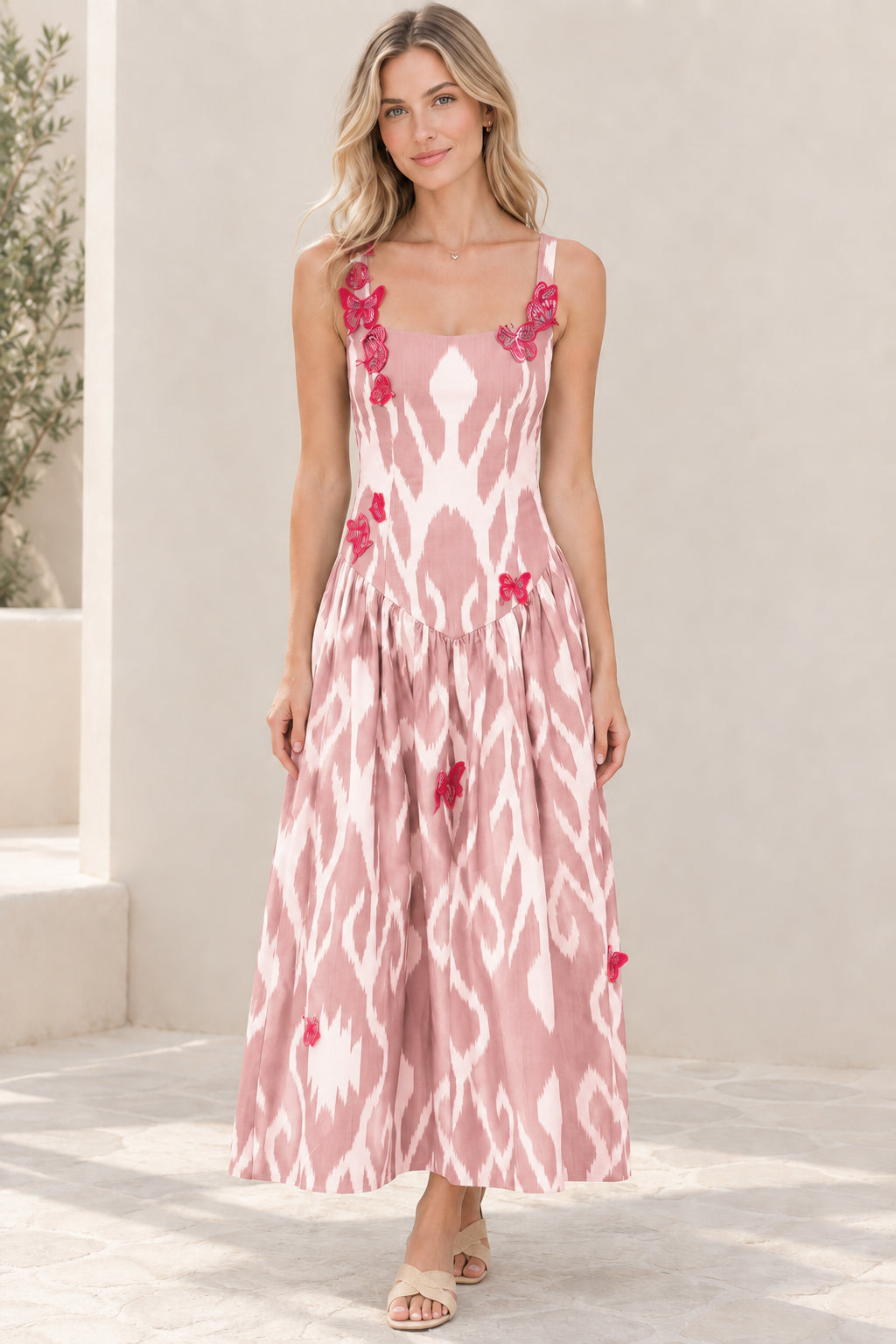 Model wearing blush pink and white ikat print sleeveless maxi dress with butterfly patches
