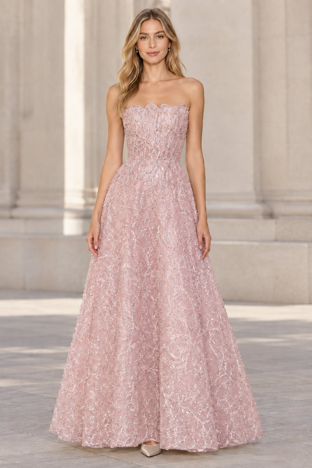 Front view of model wearing blush pink strapless embellished A-line evening gown