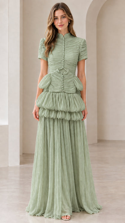 Front view of model wearing sage green mock neck tiered pleated evening gown