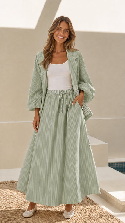 Model wearing sage green striped open-front jacket and maxi skirt set