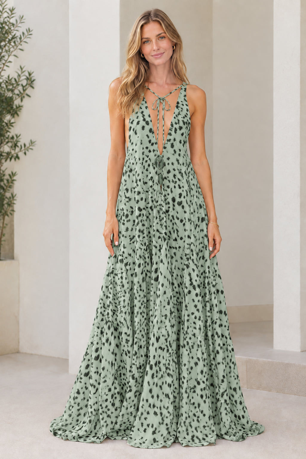 Model wearing sage green dotted sleeveless plunge tiered maxi dress