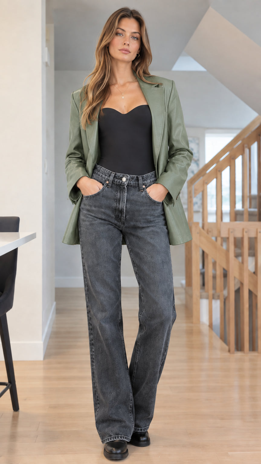 Front view of woman styling Sage Green faux leather blazer with black top and denim jeans